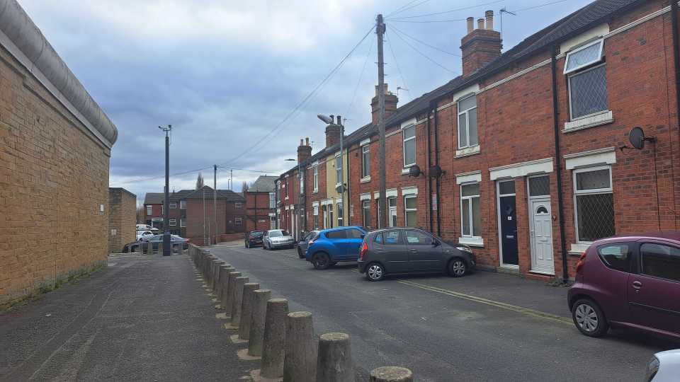 Some of the houses face the huge beige prison wall