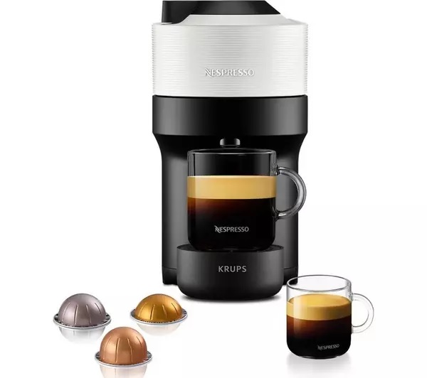 Nespresso by Krups Vertuo coffee machine with coffee pods and cups.