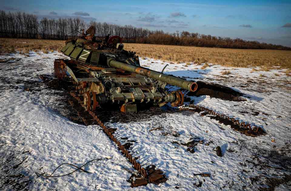 A destroyed Russian tank sits in a snow covered wheat field in Kharkiv