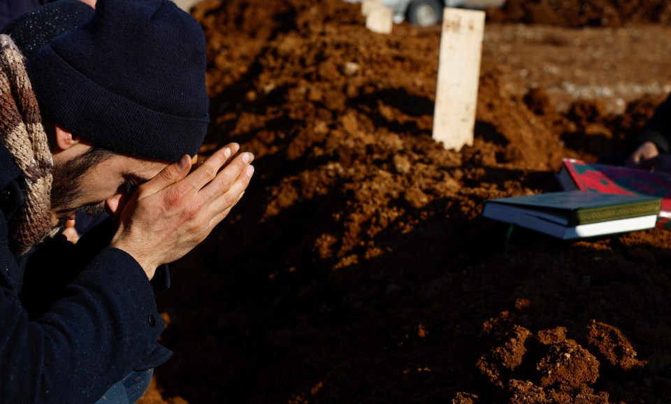 A man was pictured praying in a cemetery in Kahramanmaras, Turkey