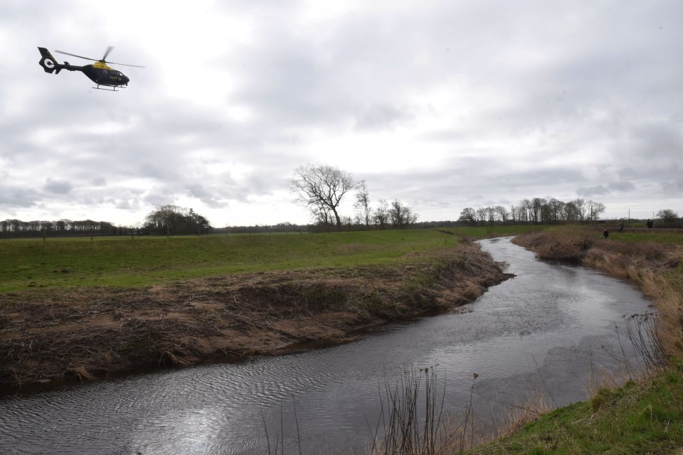 A helicopter flies near the river after the discovery of a body