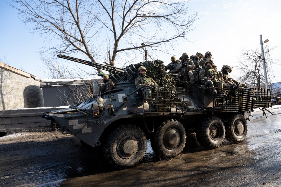 Ukrainian troops riding an armoured vehicle to the Donbas region frontline village of Torske