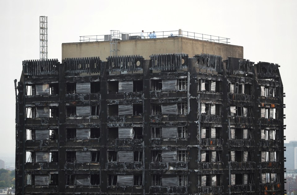 Workers seen on the roof of the burnt out remains months later