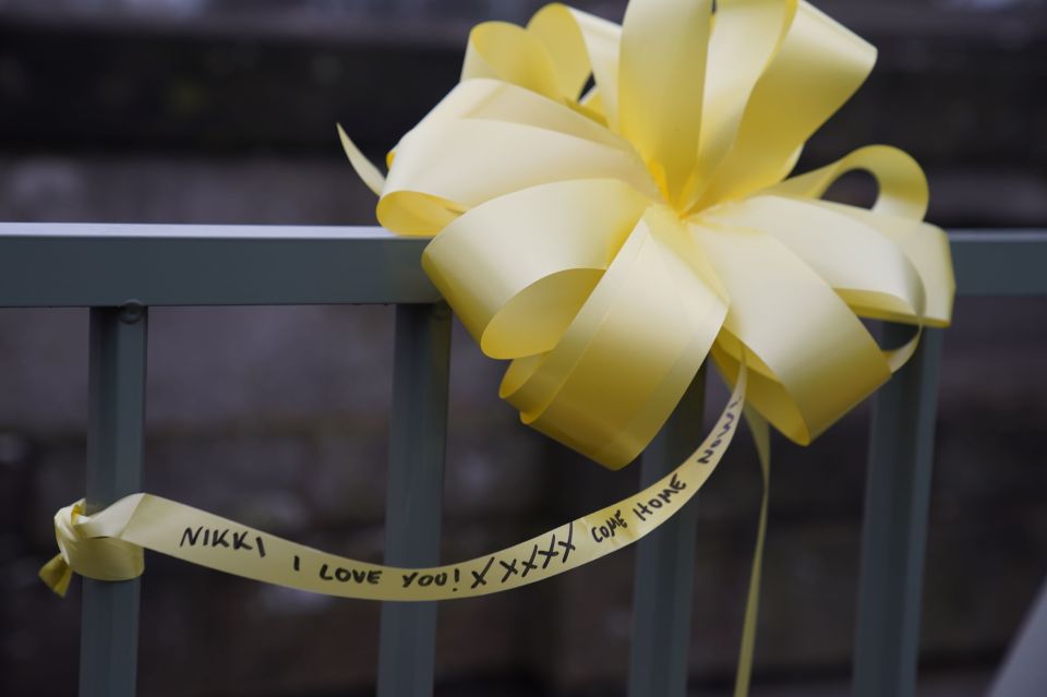 A yellow ribbon with a message of hope tied to a bridge over the River Wyre