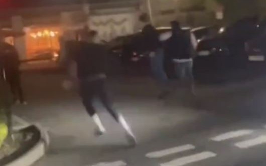 A group of men can be seen chasing another man through the car park during a chaotic brawl