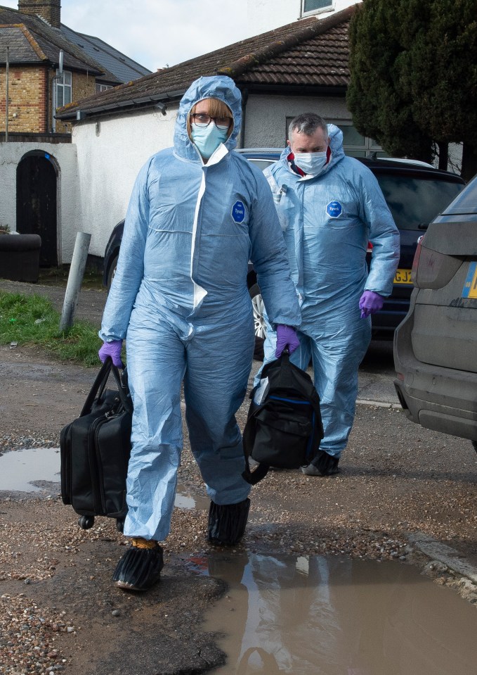 Two officers leaving the property which has a 'beware of the dog' sign on the front door