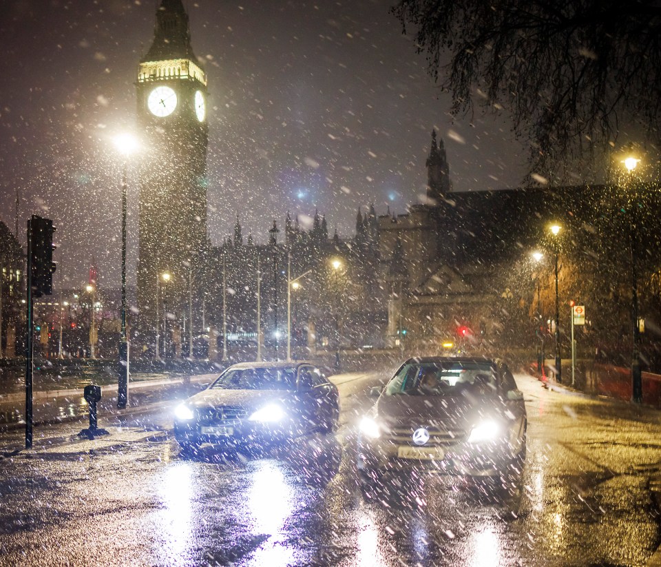 Cars make their way through the snow in Parliament Square, London