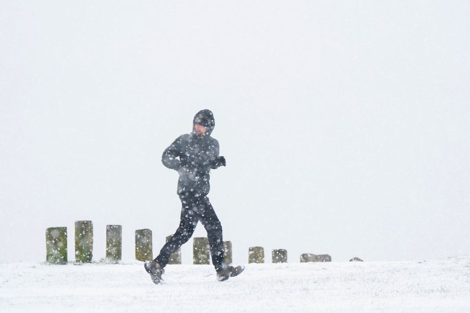 A jogger runs in the snow on the Dunstable Downs in Bedfordshire