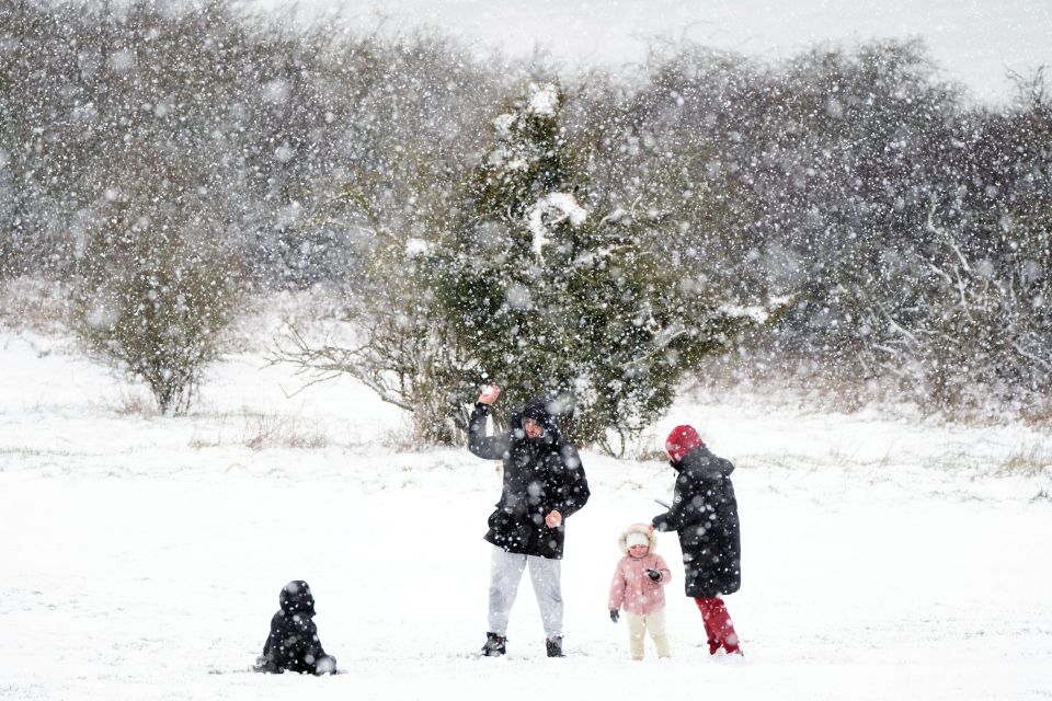 People play in the snow on the Dunstable Downs in Bedfordshire