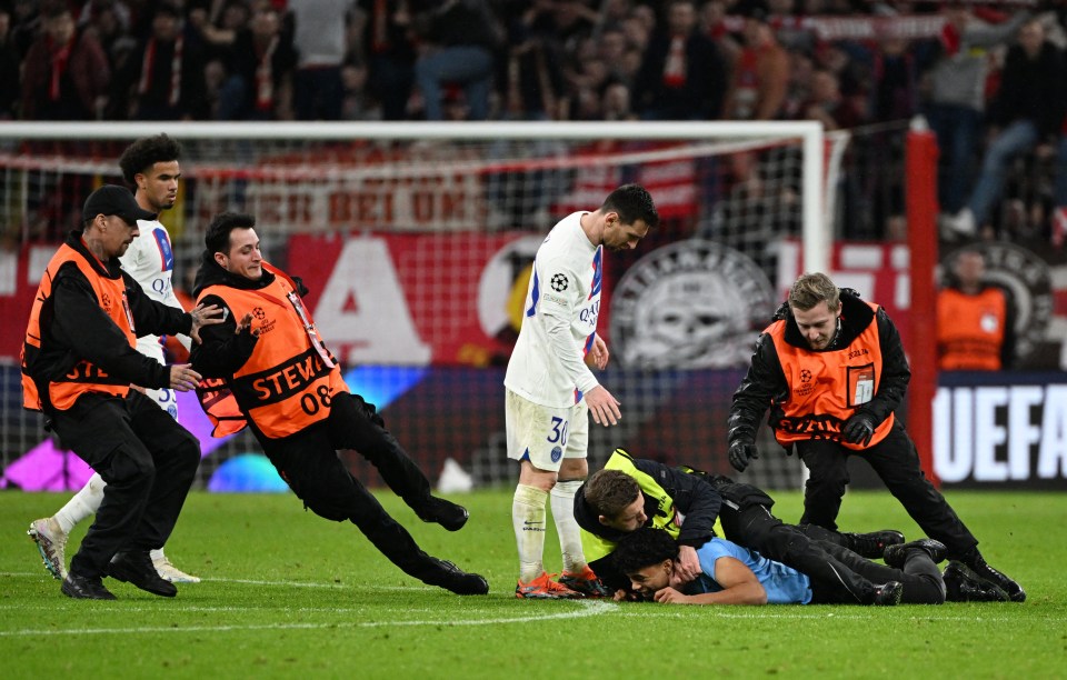 A pitch invader was wrestled down by stewards as he tried to get to Messi