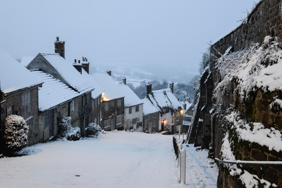 Snow covers  the steep cobbled street at Gold Hill in Shaftesbury, Dorset