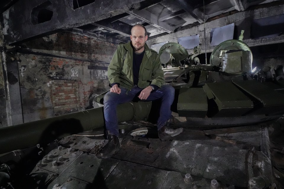 Sun defence editor Jerome Starkey with a Russian T72 b3 tank that has been refurbished in a hidden bunker near Kharkiv for use by the Ukrainian army after being left behind by retreating Russians