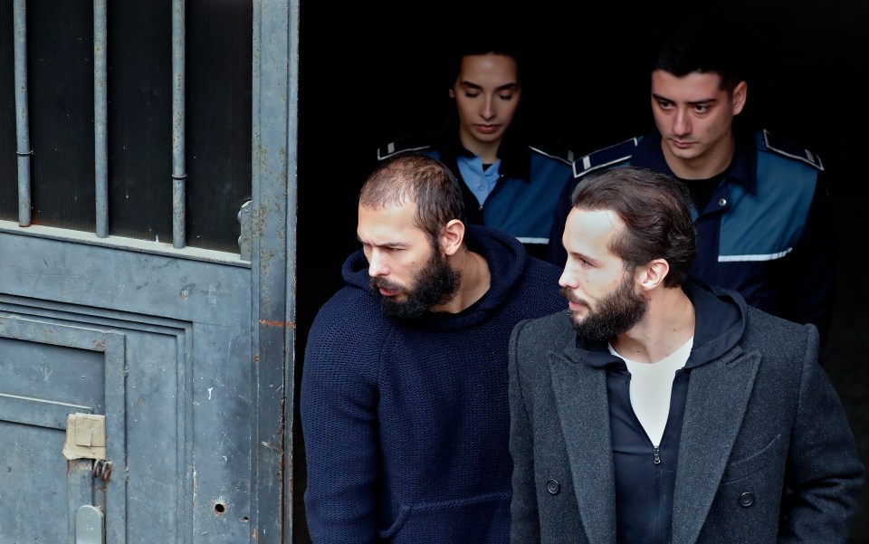 Andrew and Tristan are escorted by police officers after their hearing on February 27