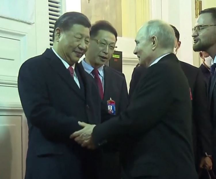 Vladimir Putin gripped Xi Jinping's arm as they shook hands and said goodbye