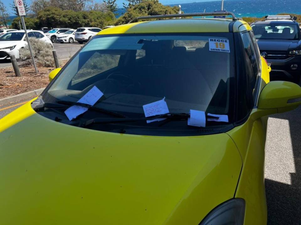 The driver of the yellow hatchback returned to their vehicle to find four handwritten notes on their car