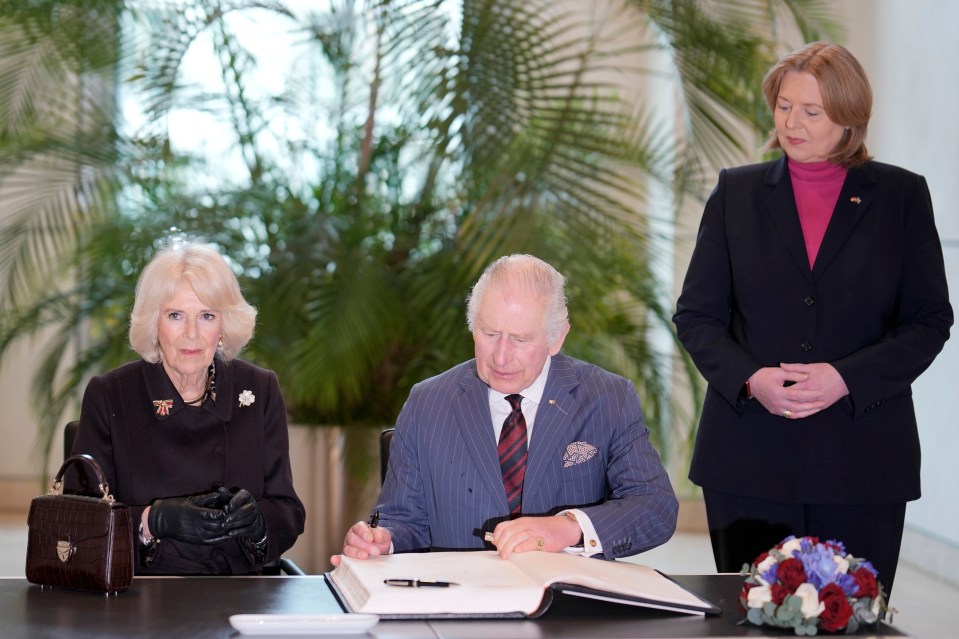 The royal couple signs the guest book at the Bundestag