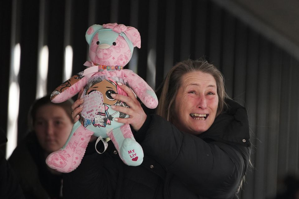 Olivia's mum Cheryl, who was also injured in the attack, holds up a teddy bear after the verdicts were delivered