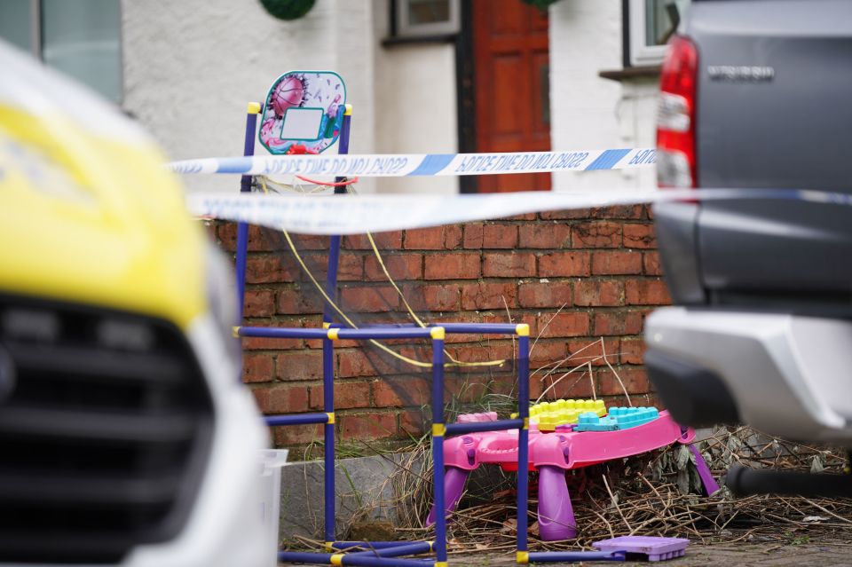 The driveway is scattered with children’s toys