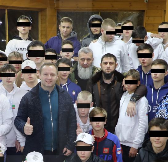 Vladimir Khromov, a representative for the Commissioner of Children’s Rights, is seen posing with children involved in the sick scheme