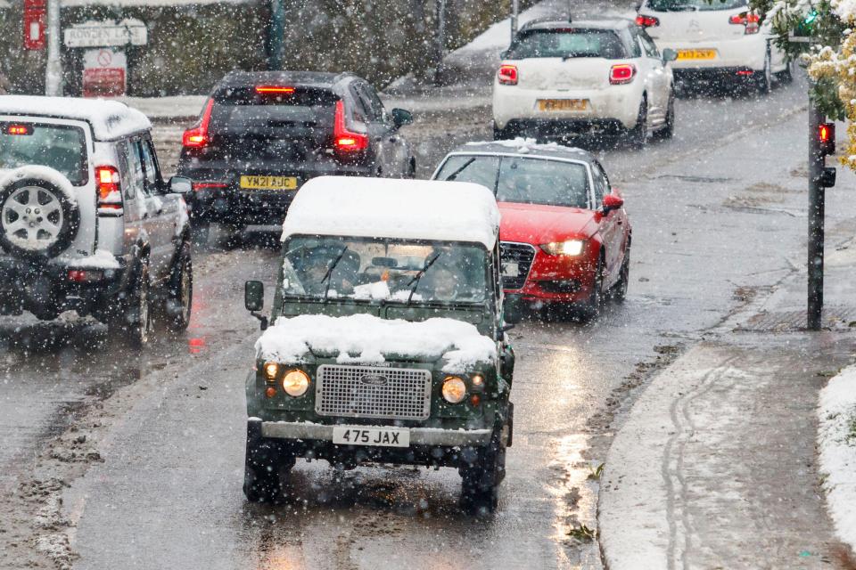 Cars make their way through the snow in Chippenham, Wiltshire