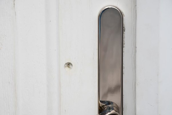 A picture shows the bullet hole made in Olivia’s front door