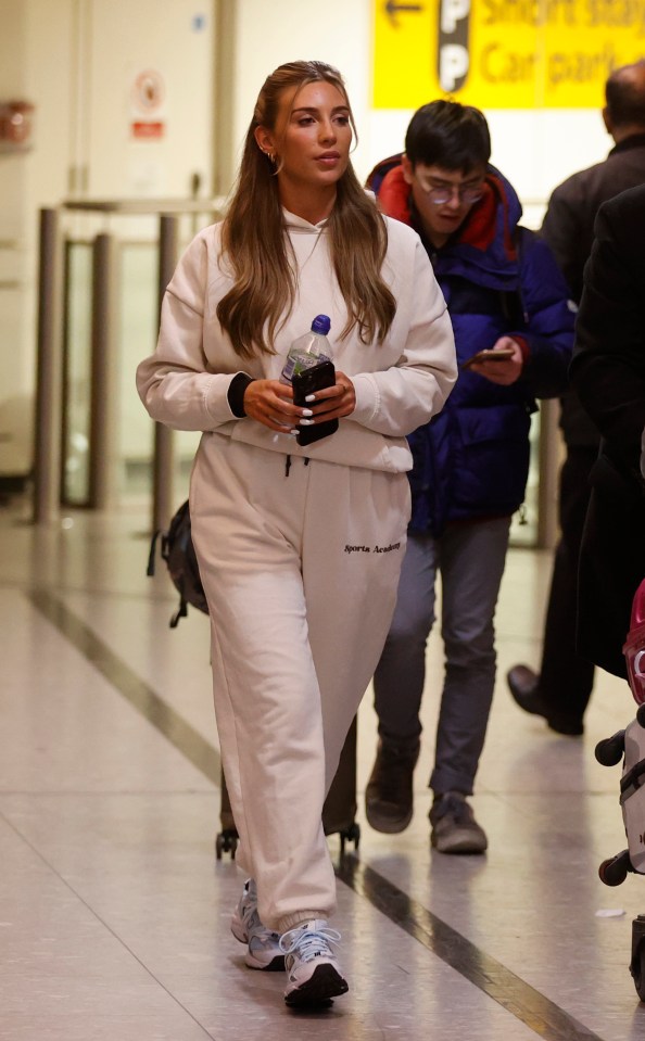 Rosie kept it casual in a beige tracksuit and trainers after the flight