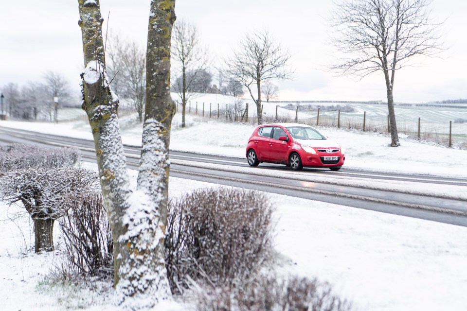 A snow-covered car takes to icy roads in Sunderland