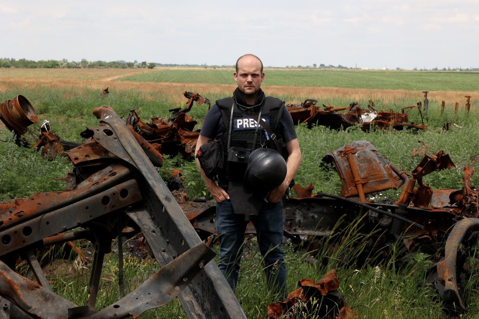 Jerome Starkey stands among destroyed Russian armour at an area outside Shevchenkove