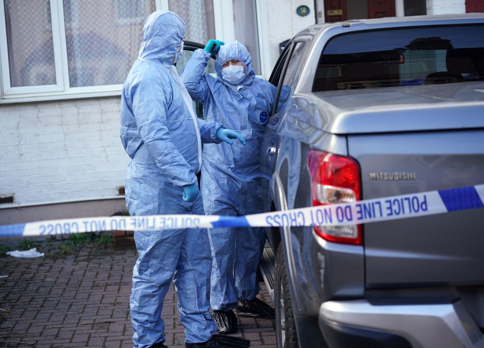 Officers examining a vehicle parked on the driveway