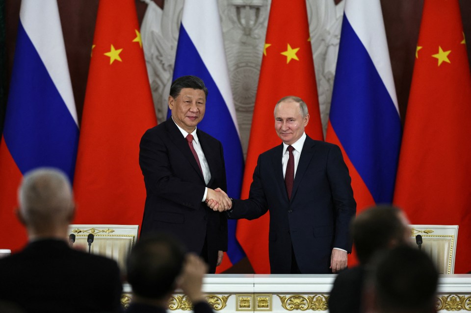 Putin shakes hands with Xi during talks