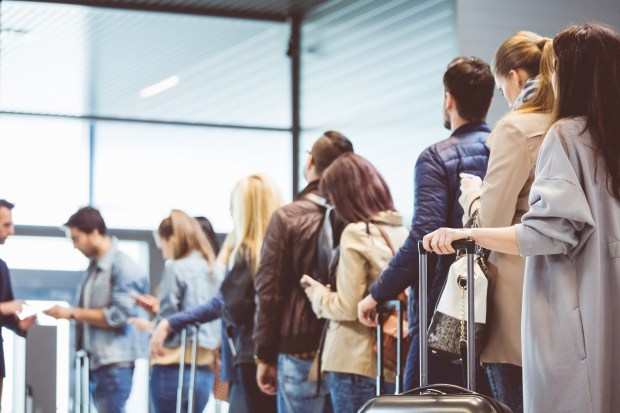 a group of people standing in a line with luggage