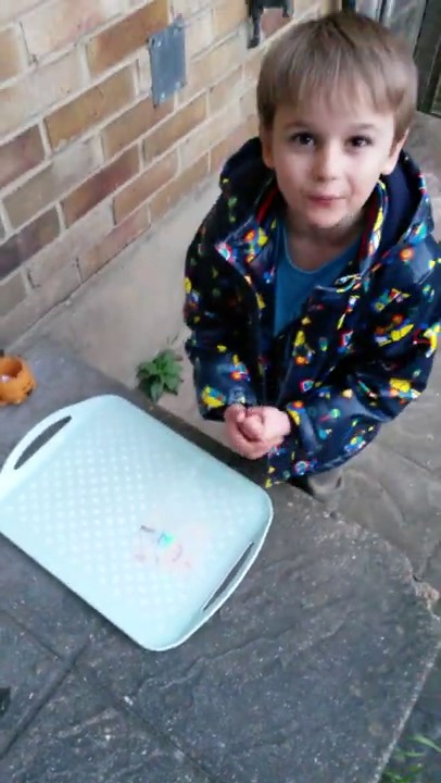 Little Max performs a 'magic trick' on steps outside his home