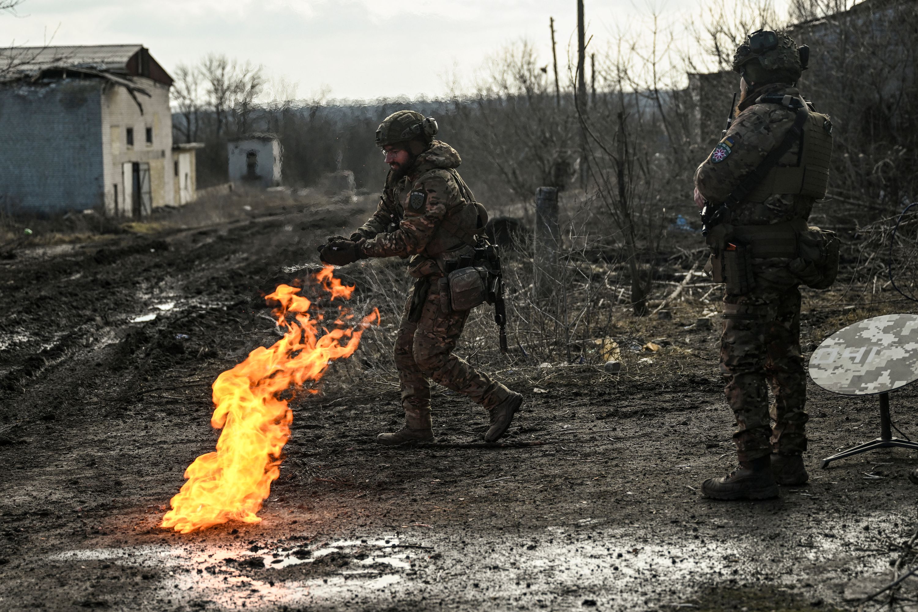 Ukrainian servicemen light a fire with gun powder to get warm