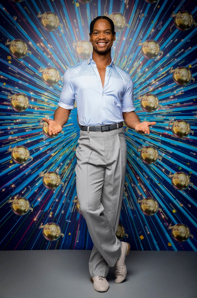 a man stands in front of a blue background with dancing with the stars written on it