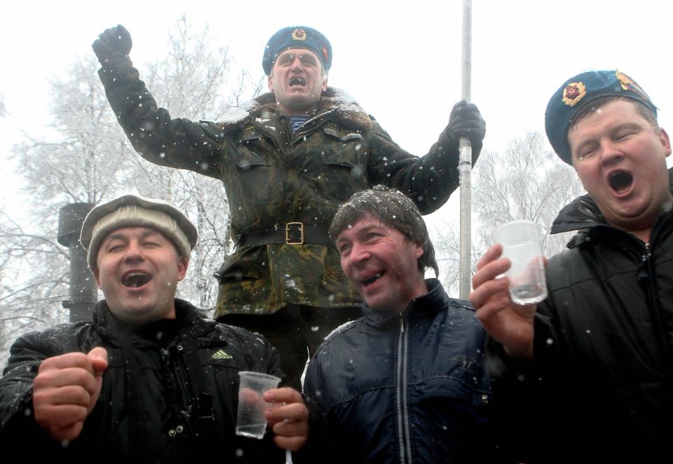 Russian veterans of the Afghan war drink vodka during a rally