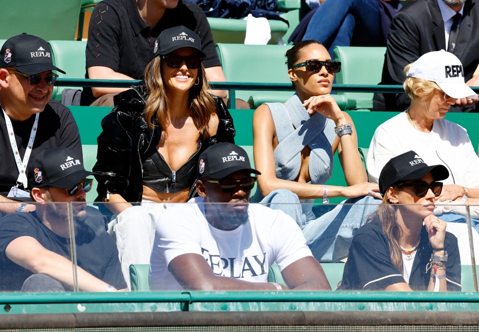 Supermodels Izabel Goulart and Cindy Bruna sit behind Usain Bolt at the Monte-Carlo Masters