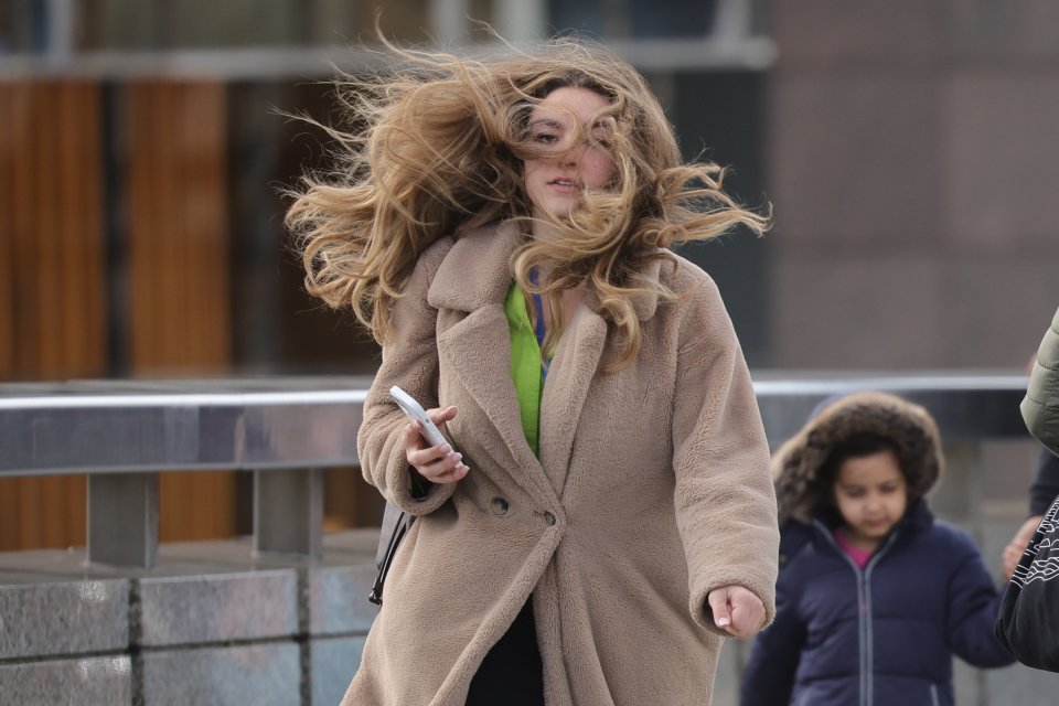 A woman's hair gets blown about as she walks across London Bridge in Central London earlier today