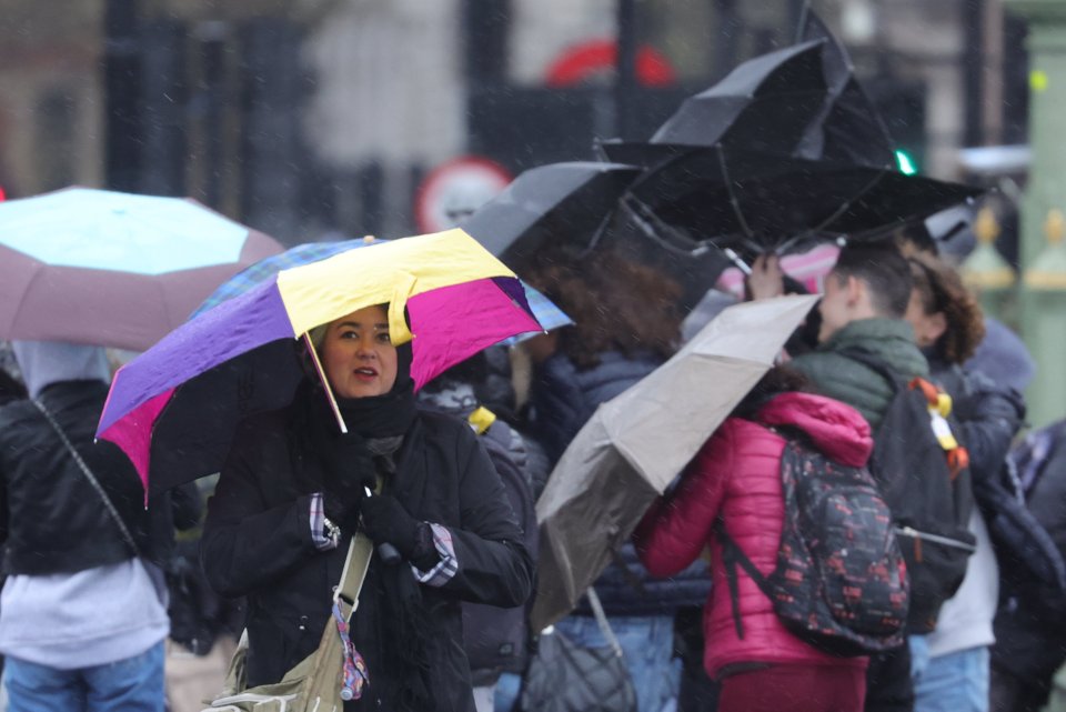 People battle the wind and the rain on Westminster Bridge yesterday