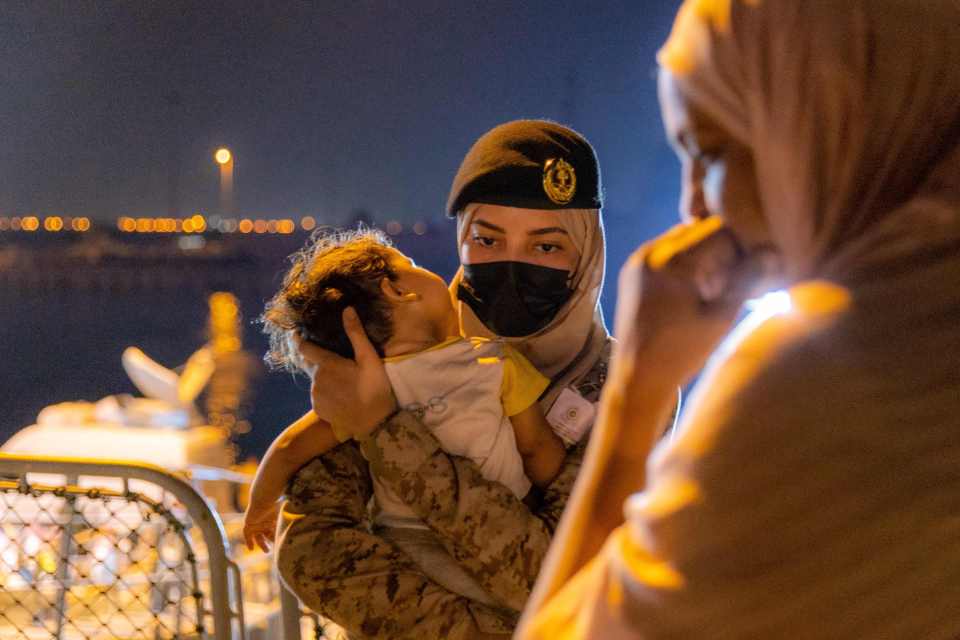 A Saudi soldier carries a baby from an evacuation ship