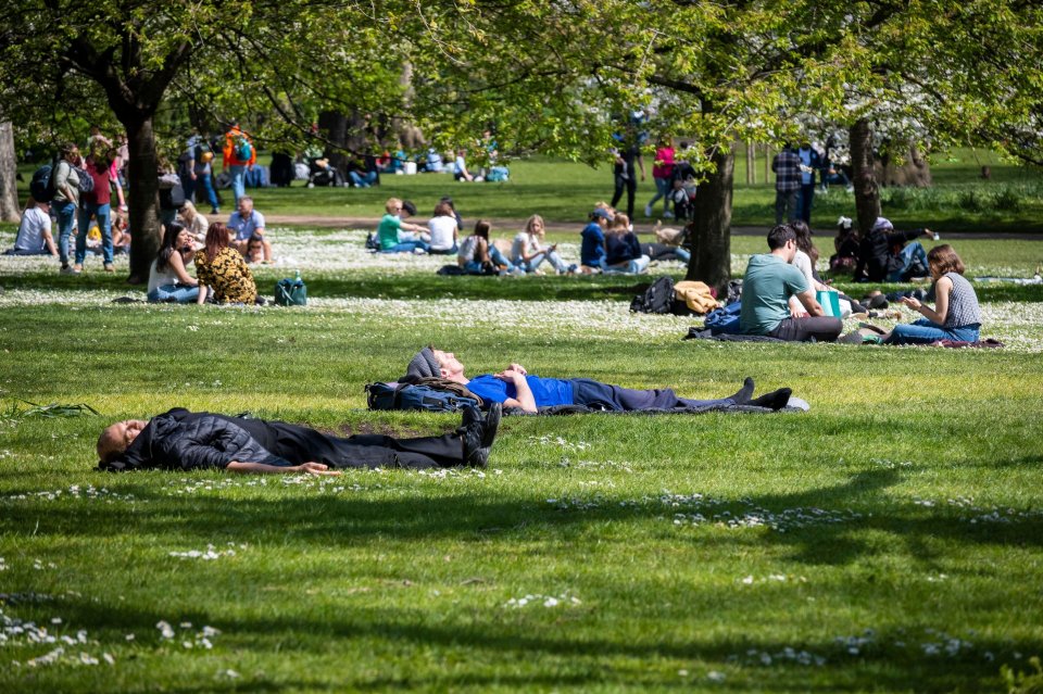 People take it easy in St James's Park, central London, today