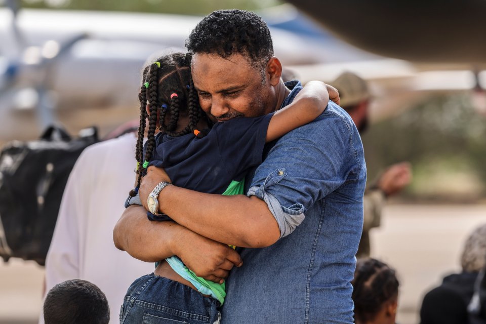 A relieved father hugs his daughter before boarding a RAF aircraft that will take them to Cyprus