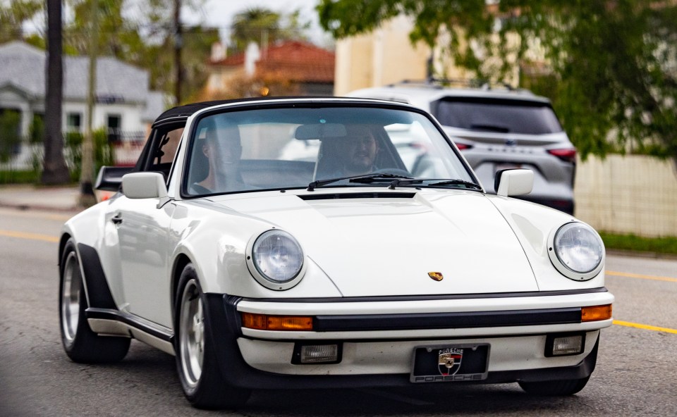 Edwin is seen behind the wheel of his vintage Porsche 911