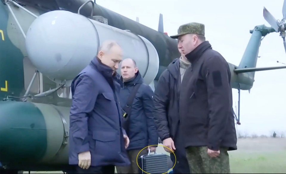 Putin pictured with his notorious briefcase