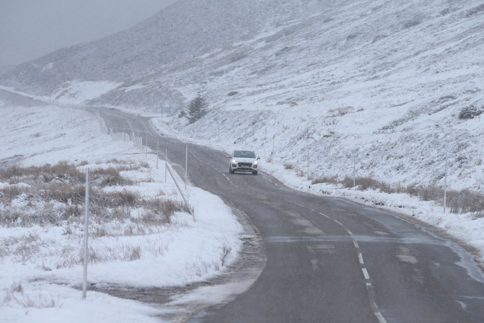 Traffic on the A939 near Tomintoul today as fresh snow falls in the North of Scotland