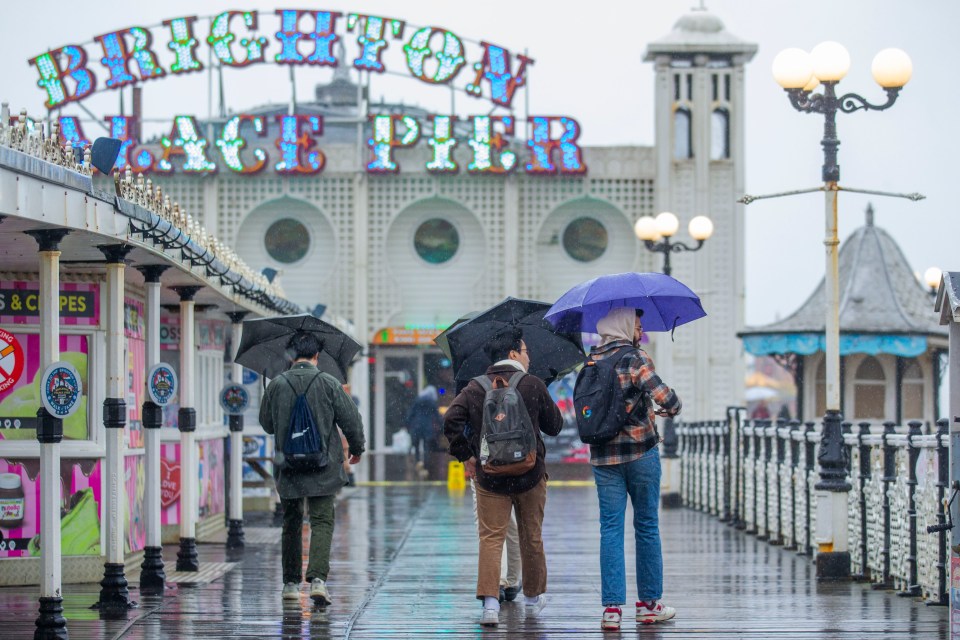 People try to keep dry while out on Brighton Pier on Easter Monday