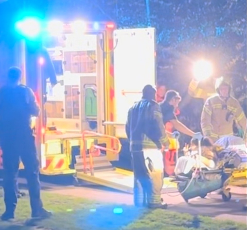 The woman made a piece sign as she was stretchered into an ambulance