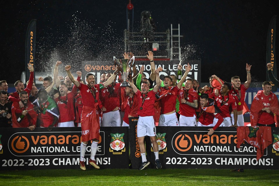 The players celebrate after securing promotion with a 3-1 victory over Boreham Wood