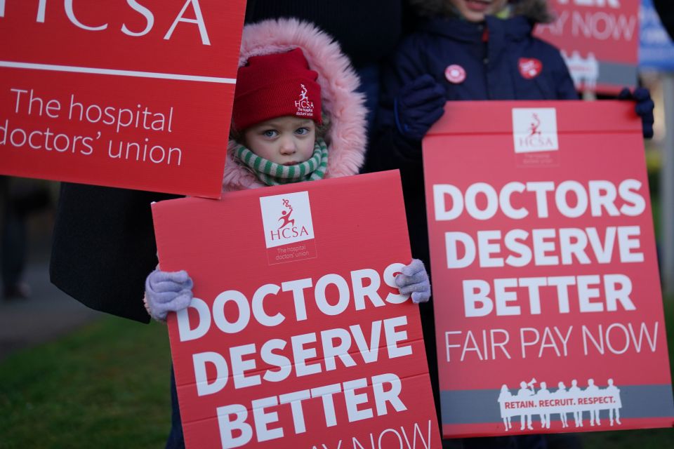 A child joins striking NHS junior doctors on the picket line outside Leicester Royal Infirmary