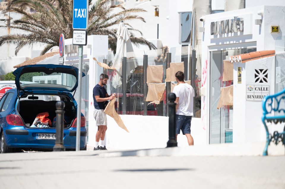 Two men were seen covering up the graffiti outside the restaurant