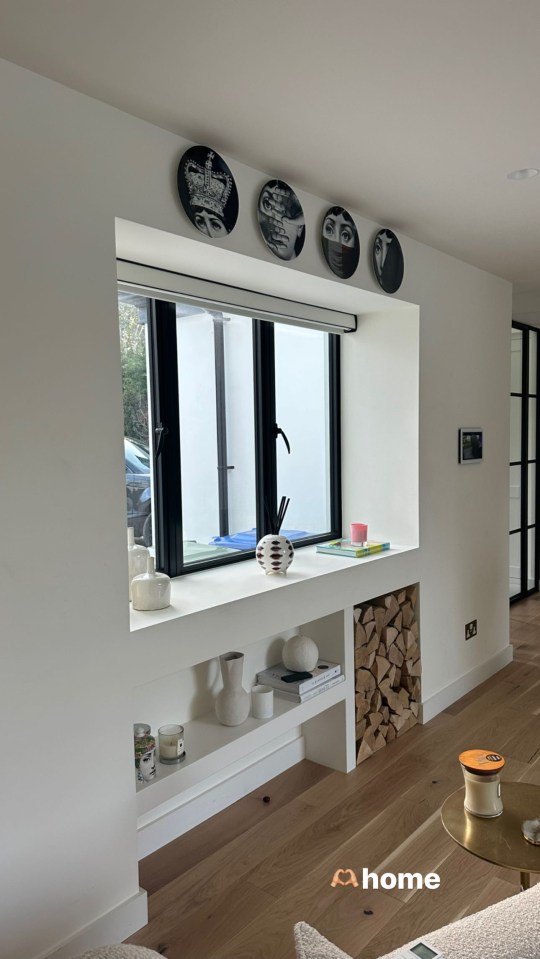 The walls have been painted a fresh white with exposed log detail and a laminate floor